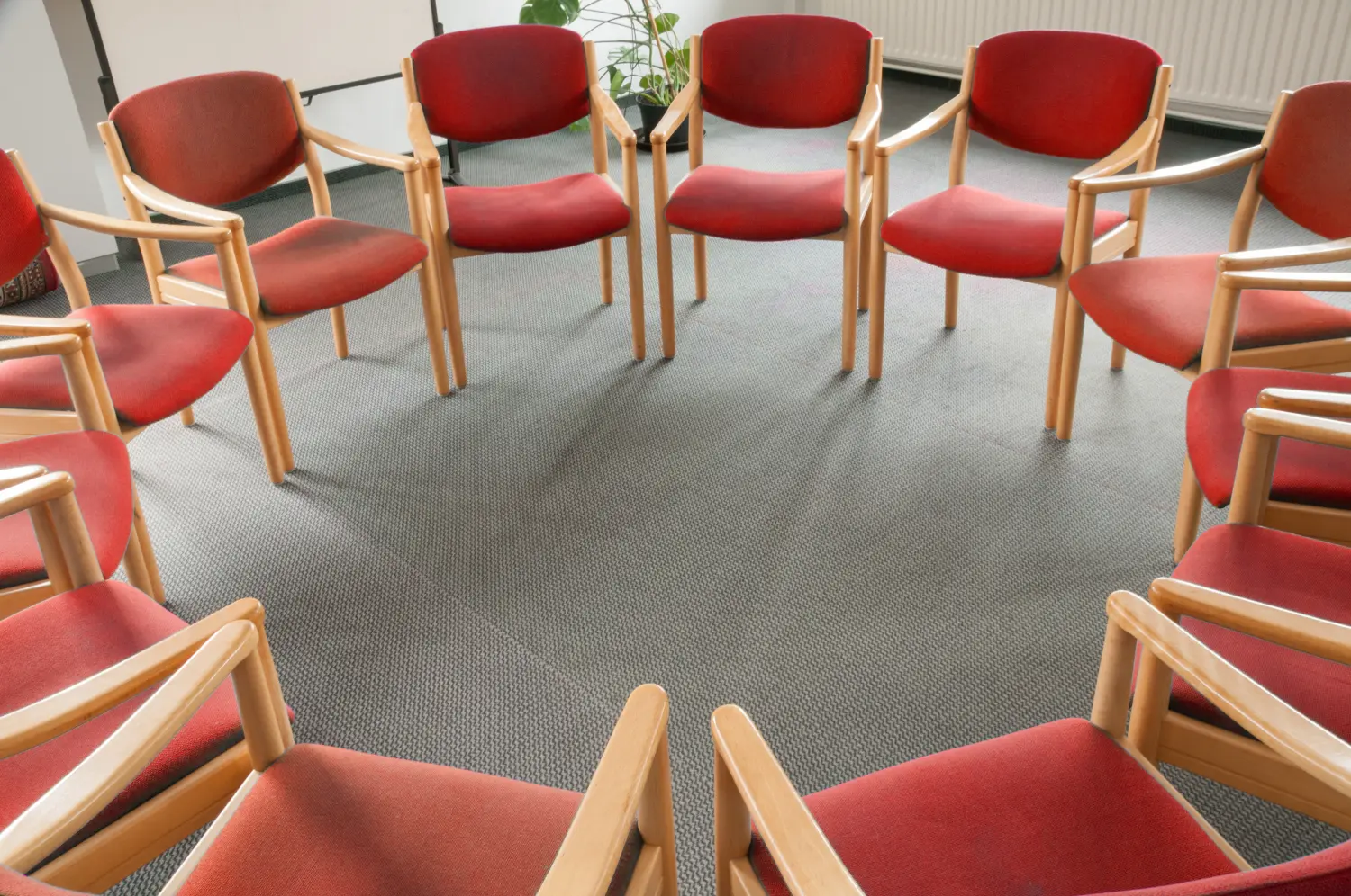 rote Stühle im Kreis sindulka systemisch